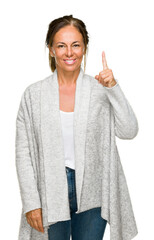 Poster - Beautiful middle age adult woman wearing winter sweater over isolated background showing and pointing up with finger number one while smiling confident and happy.