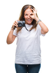 Wall Mural - Middle age hispanic woman taking pictures using vintage photo camera over isolated background with happy face smiling doing ok sign with hand on eye looking through fingers