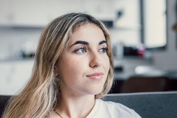 Wall Mural - Head shot close up dreamy young smiling beautiful woman looking away, visualizing future indoors of recollecting good memories. Happy healthy millennial girl enjoying free weekend time at home..