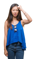 Sticker - Young asian woman over isolated background angry and mad raising fist frustrated and furious while shouting with anger. Rage and aggressive concept.