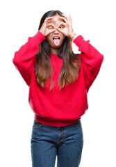 Canvas Print - Young asian woman wearing winter sweater over isolated background doing ok gesture like binoculars sticking tongue out, eyes looking through fingers. Crazy expression.