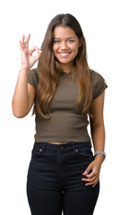 Canvas Print - Young beautiful brunette woman over isolated background smiling positive doing ok sign with hand and fingers. Successful expression.