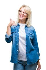 Canvas Print - Young beautiful blonde woman wearing glasses over isolated background smiling doing phone gesture with hand and fingers like talking on the telephone. Communicating concepts.