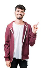 Canvas Print - Young handsome man over isolated background with a big smile on face, pointing with hand and finger to the side looking at the camera.