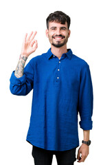 Canvas Print - Young handsome man over isolated background smiling positive doing ok sign with hand and fingers. Successful expression.