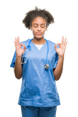 Poster - Young afro american doctor woman over isolated background relax and smiling with eyes closed doing meditation gesture with fingers. Yoga concept.