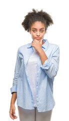 Wall Mural - Young afro american woman over isolated background looking confident at the camera with smile with crossed arms and hand raised on chin. Thinking positive.