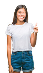 Poster - Young asian woman over isolated background doing happy thumbs up gesture with hand. Approving expression looking at the camera with showing success.