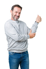 Canvas Print - Handsome middle age senior man wearing a sweatshirt over isolated background Looking proud, smiling doing thumbs up gesture to the side