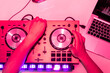 © ADDICTIVE STOCK - DJ adjusting equipment with intense pink lighting
