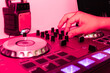 © ADDICTIVE STOCK - Hand manipulating a DJ controller in a vivid pink light