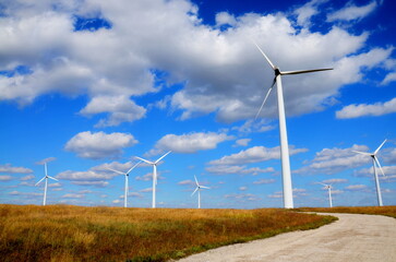 Green renewable energy concept - wind generator turbines in field blue sky. Wind green environment energy turbine generator construction, renewable green energy. Eco power wind turbine mill generator