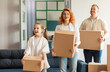 © Home-stock - Happy parents and daughter moving to new house, carrying carton boxes into new apartment. Real estate concept
