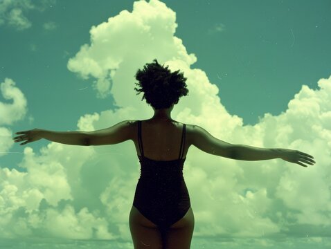Medium shot of A beautiful woman in black leotards dancing with her arms outstretched, silhouetted against the sky, shot from behind in a movie still, minimalist style