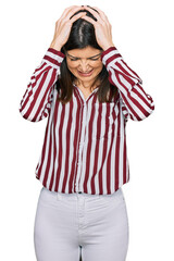 Wall Mural - Beautiful brunette woman wearing striped shirt suffering from headache desperate and stressed because pain and migraine. hands on head.