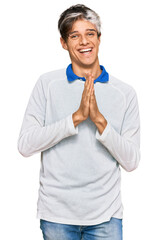 Sticker - Young hispanic man wearing casual clothes praying with hands together asking for forgiveness smiling confident.