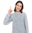 © Krakenimages.com - Young caucasian girl wearing casual clothes showing and pointing up with finger number one while smiling confident and happy.