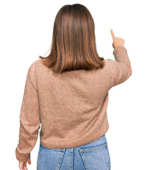 Poster - Young beautiful woman wearing casual clothes posing backwards pointing ahead with finger hand