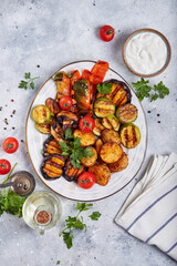 Canvas Print - Grilled vegetables: eggplant, zucchini, potatoes, bell pepper, mushrooms, tomatoes. Served with yogurt sour cream sauce. Top view. Plate of healthy food.