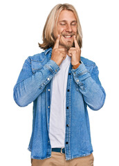 Poster - Caucasian man with blond long hair wearing casual denim jacket smiling with open mouth, fingers pointing and forcing cheerful smile