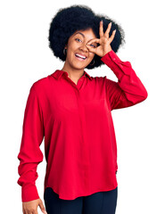 Poster - Young african american girl wearing casual clothes doing ok gesture with hand smiling, eye looking through fingers with happy face.