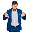 © Krakenimages.com - Young hispanic man wearing business jacket pointing down with fingers showing advertisement, surprised face and open mouth