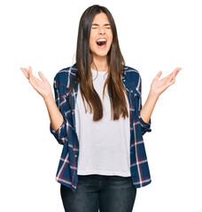 Wall Mural - Young brunette woman wearing casual clothes celebrating mad and crazy for success with arms raised and closed eyes screaming excited. winner concept