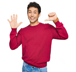 Wall Mural - Young handsome man wearing casual clothes showing and pointing up with fingers number six while smiling confident and happy.