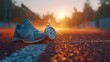 © muji - Running Shoe and Stopwatch on Track at Sunrise