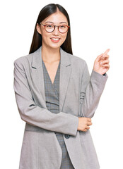 Poster - Young chinese woman wearing business clothes smiling happy pointing with hand and finger to the side