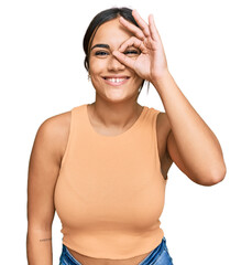 Wall Mural - Young brunette woman wearing casual clothes doing ok gesture with hand smiling, eye looking through fingers with happy face.