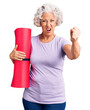 © Krakenimages.com - Senior grey-haired woman holding yoga mat annoyed and frustrated shouting with anger, yelling crazy with anger and hand raised