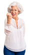 © Krakenimages.com - Senior grey-haired woman wearing casual clothes angry and mad raising fist frustrated and furious while shouting with anger. rage and aggressive concept.