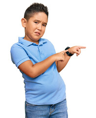 Sticker - Little boy hispanic kid wearing casual clothes pointing aside worried and nervous with both hands, concerned and surprised expression