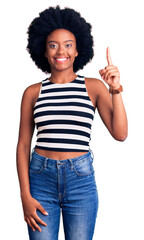 Poster - Young african american woman wearing casual clothes pointing finger up with successful idea. exited and happy. number one.