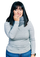 Canvas Print - Young hispanic plus size woman wearing winter scarf looking stressed and nervous with hands on mouth biting nails. anxiety problem.