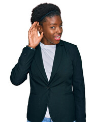 Poster - Young african american girl wearing business clothes smiling with hand over ear listening an hearing to rumor or gossip. deafness concept.