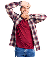 Wall Mural - Young handsome man wearing casual shirt smiling cheerful playing peek a boo with hands showing face. surprised and exited