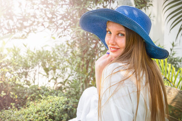 Portrait of a girl in a hat among palm trees