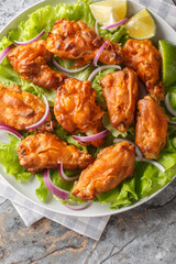 Canvas Print - Fried Tom Yam Chicken is an Asian inspired Thai Style deep fried dish closeup on the plate on the table. Vertical top view from above