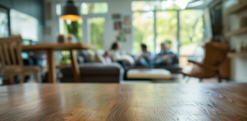 Blurred living room with wooden table foreground. Cozy living room with family out of focus, ideal for product placement or interior design concepts.