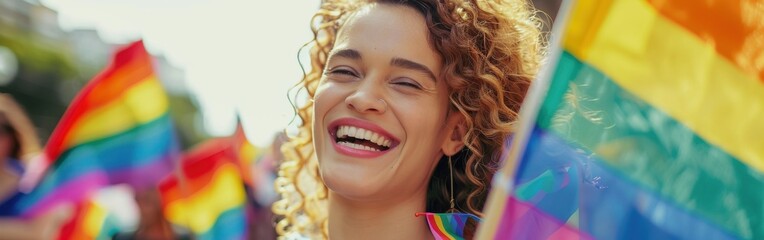 Poster - A woman is holding a rainbow flag and smiling. Concept of joy and celebration, as the woman is participating in a pride parade or a rainbow-themed event. The vibrant colors of the flag