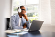 © Andrey Popov - Young African American student embraces online studying with laptop