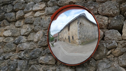 Mirror on stone wall. Reflection in rural area.