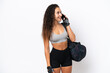 © luismolinero - Young sport Arab woman with sport bag isolated on white background keeping a conversation with the mobile phone