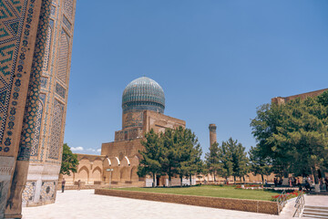 A large building with a dome on top and a small building in the background. The sky is clear and blue