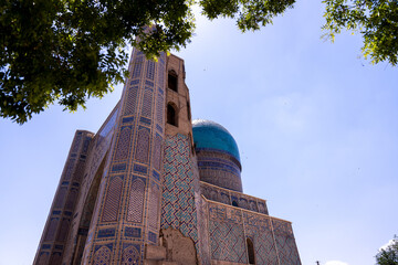 Sticker - A blue dome sits atop a building with a blue roof. The building is old and has a lot of detail on it. The sky is clear and blue, and the sun is shining brightly