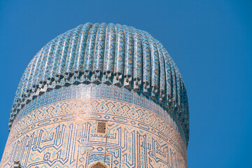 a blue dome on top of a building with a blue sky in the background. the dome is decorated with intri