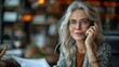 © Photolife   - portrait of a beautiful caucasian mature business woman in glasses talking smiling on the phone while in the office