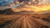 A long, dusty dirt road stretching across the open desert landscape